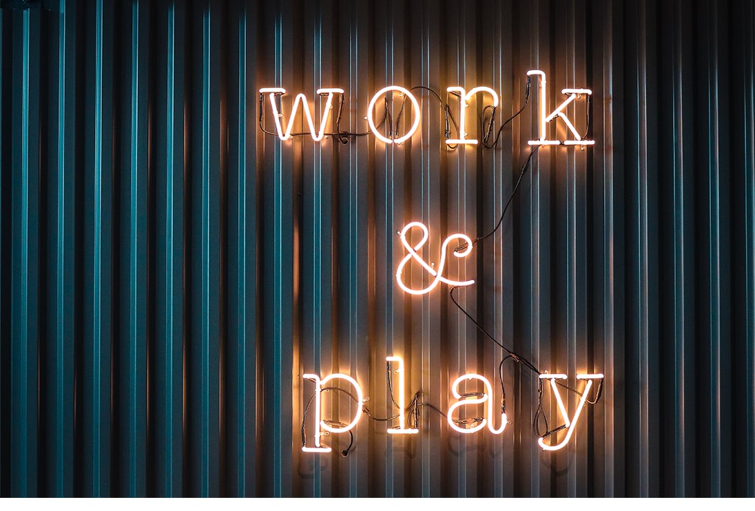 Neon "Work and Play" sign on a dark corrugated wall — placeholder editorial cover.